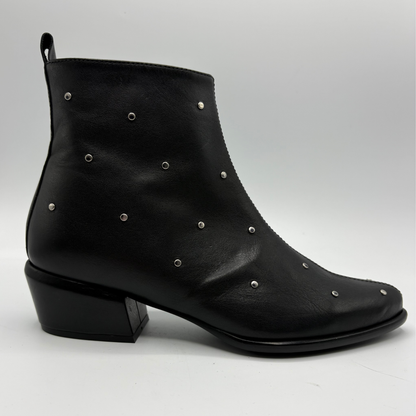 A black leather ankle boot with silver metal studs and a low block heel, shown from a side profile on a light gray background.