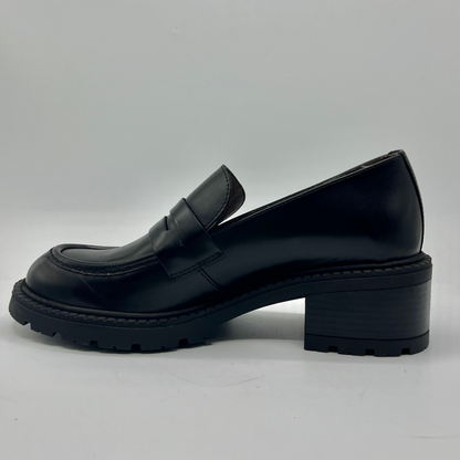 Black leather loafer shoe on a light gray background