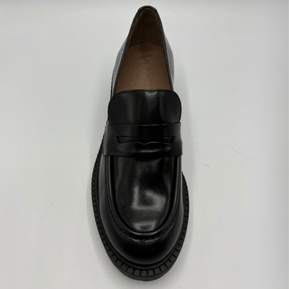 A single black leather penny loafer with a chunky black sole, photographed from a top-down angle on a light gray background.