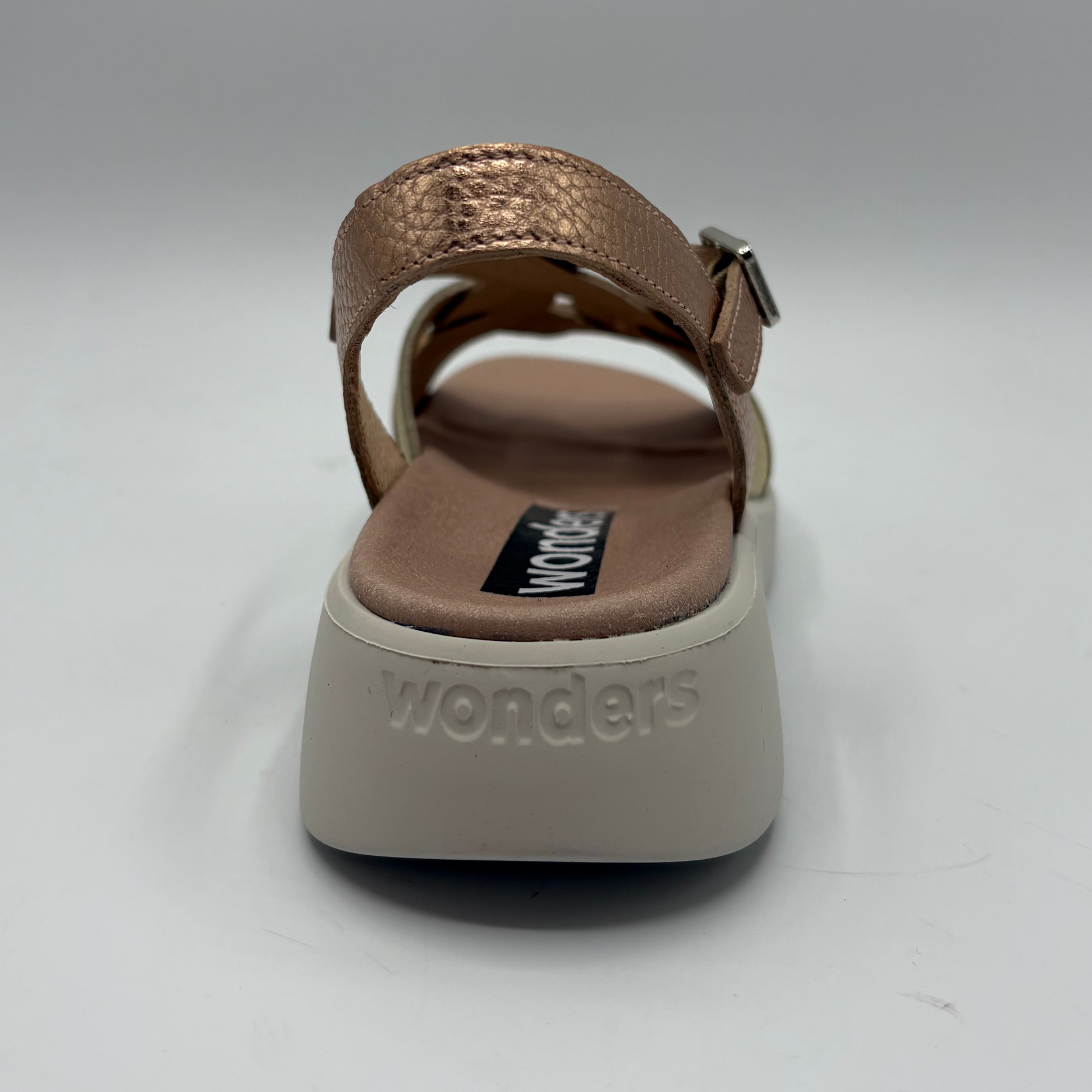 Brown sandal with 'wonders' branding on a white background
