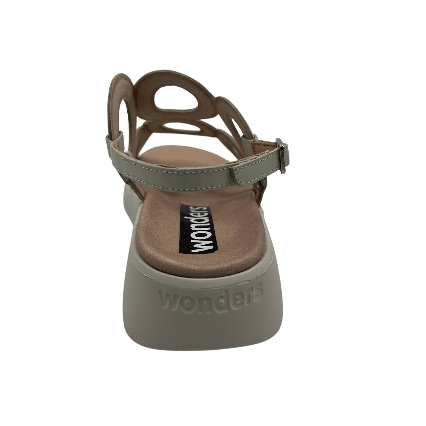 Back view of cream leather sandal with a circular patterned upper, sling back strap and low wedge outsole.