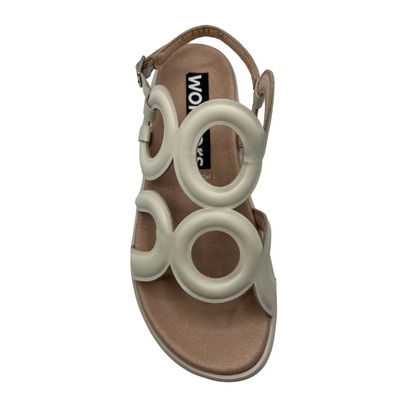 Top view of cream leather sandal with a circular patterned upper, sling back strap and low wedge outsole.