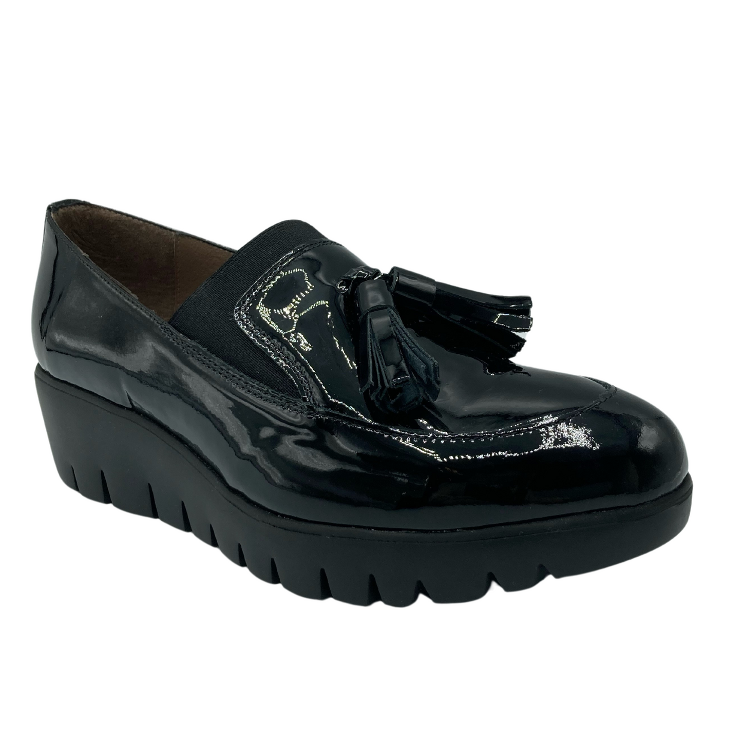 45 degree angled view of black patent loafer with tassel detail on toe box