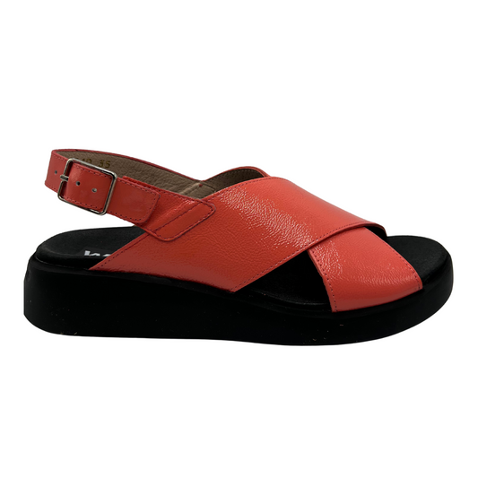 Right facing view of coral coloured leather sandal. Black outsole with a contoured footbed and adjustable slingback strap.