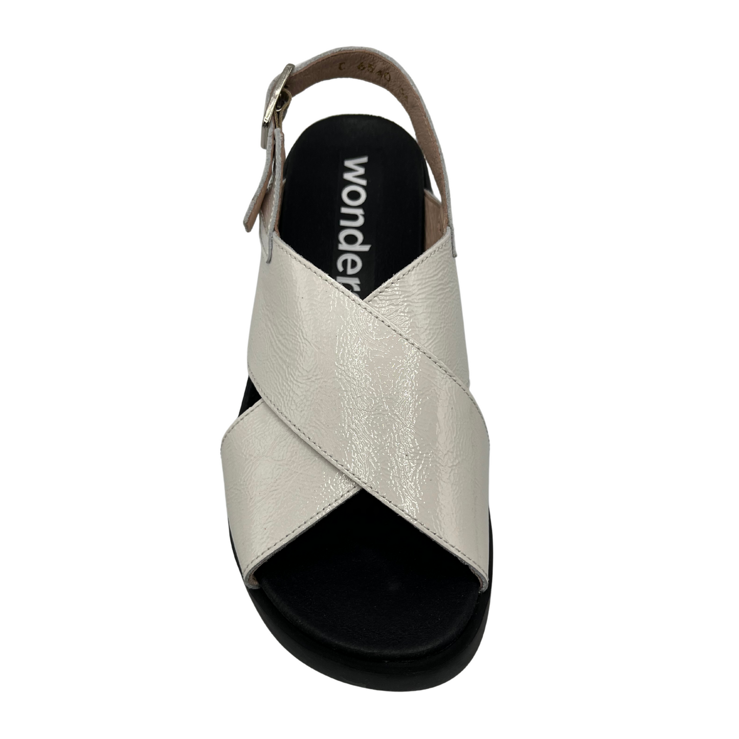 Top view of white coloured leather sandal. Black outsole with a contoured footbed and adjustable slingback strap.