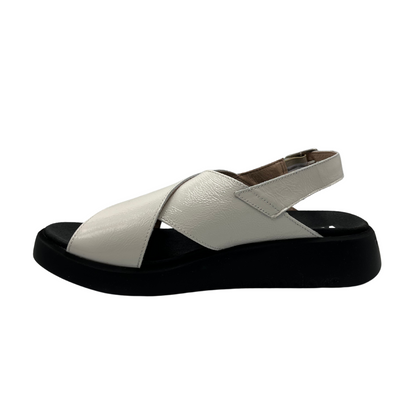 Left facing view of white coloured leather sandal. Black outsole with a contoured footbed and adjustable slingback strap.