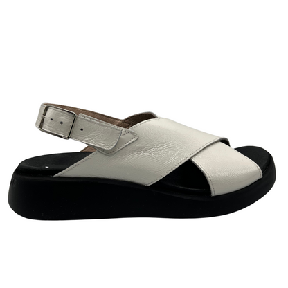 Right facing view of white coloured leather sandal. Black outsole with a contoured footbed and adjustable slingback strap.