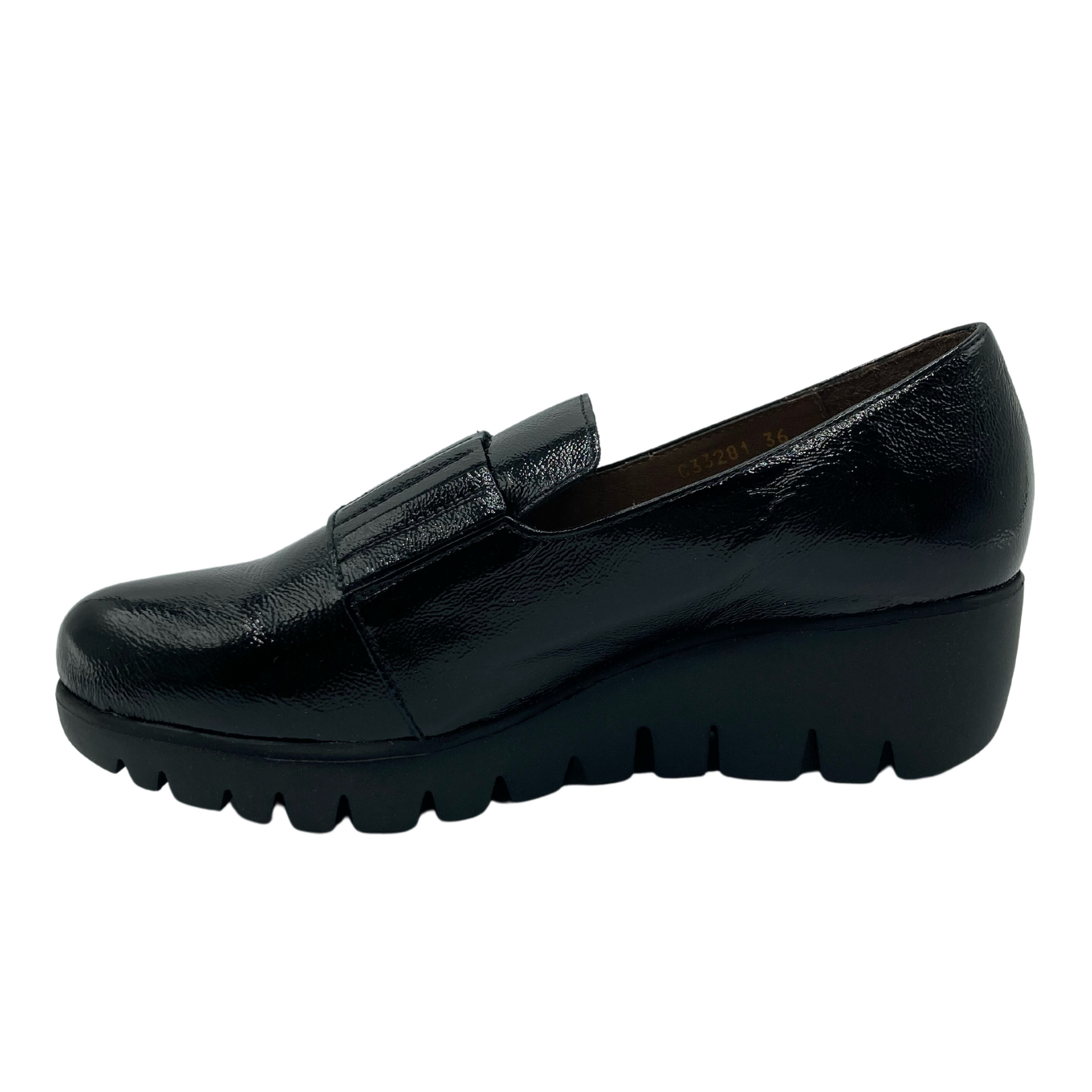 Left facing view of black patent leather shoe
