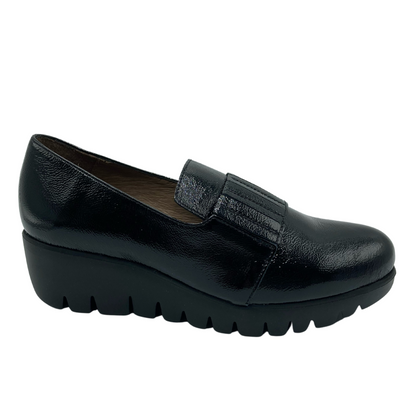 Side view of black textured leather loafer with chunky black heel