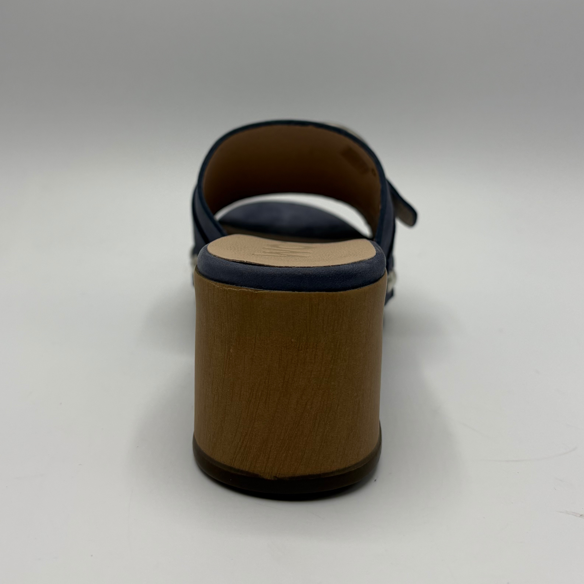 Brown sandal with a visible sole on a light gray background