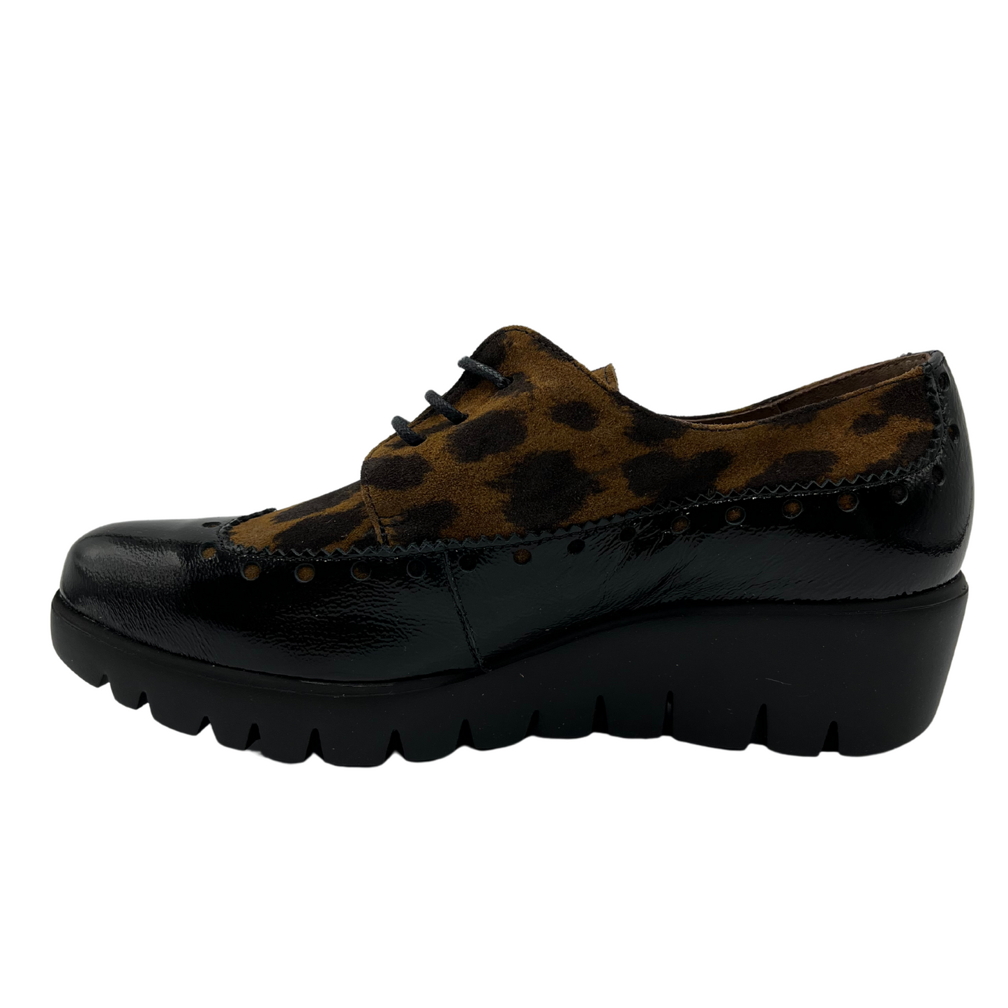 Left view of leopard print suede and black patent leather shoe with low wedge heel. 