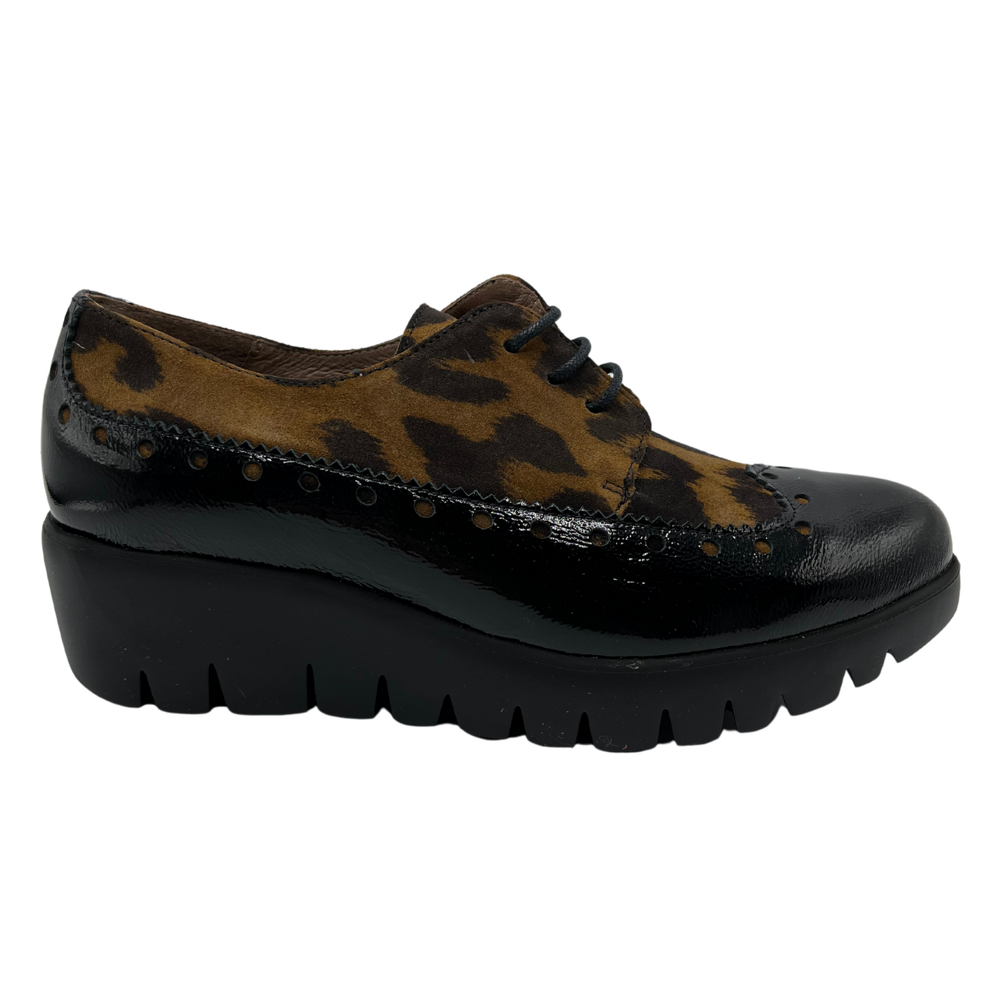 Right facing view of leopard print suede and black patent leather shoe with low wedge heel. 