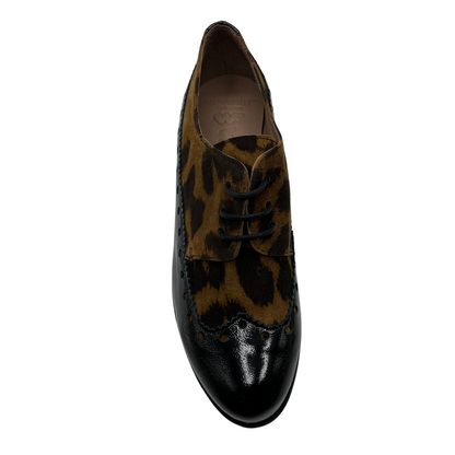 Top view of leopard print suede and black patent leather shoe with low wedge heel. 