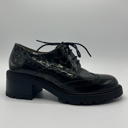 Black patent leather shoe on a gray background