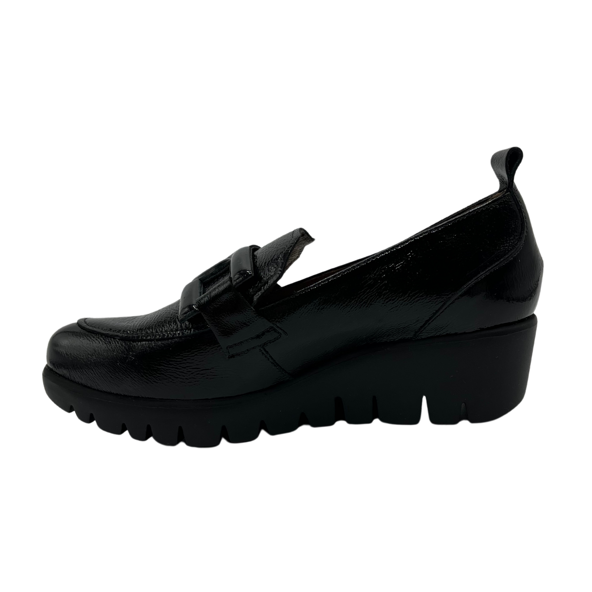 Left facing view of black patent leather loafer with wedge lug sole