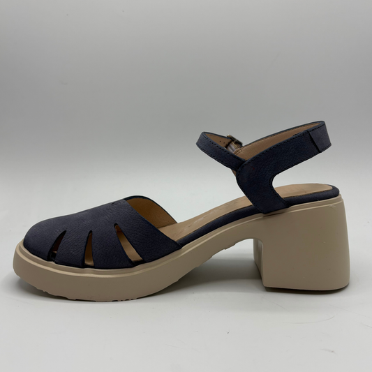Navy sandal with beige block heel on a gray background