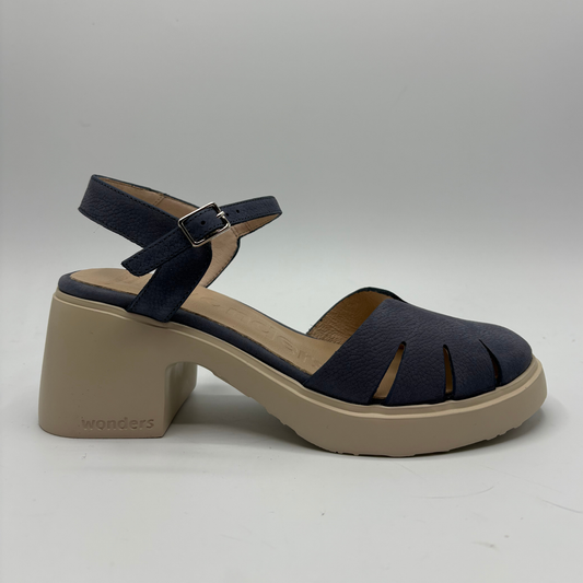 Navy sandal with beige block heel on a gray background