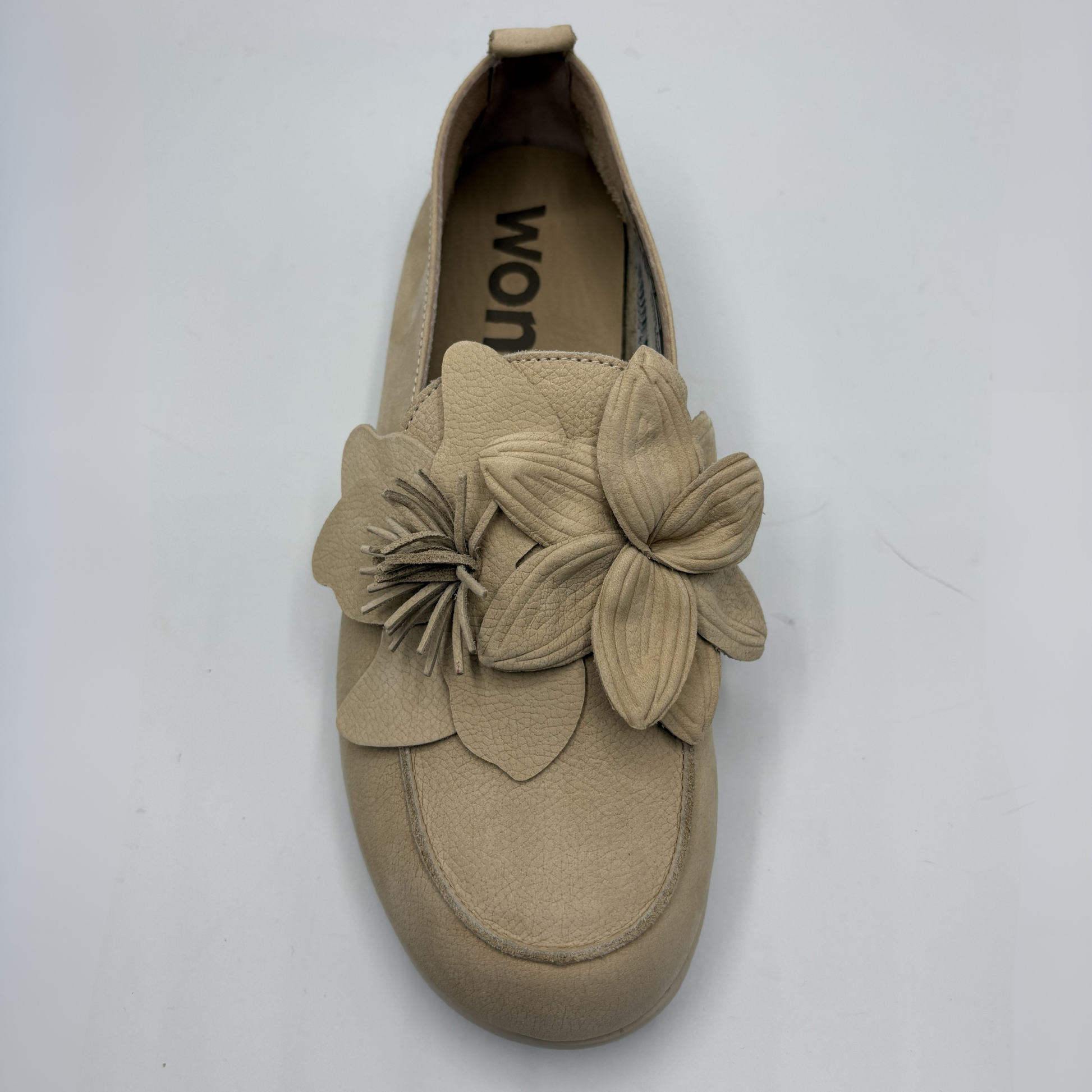 Beige slip-on shoe with floral design on a white background