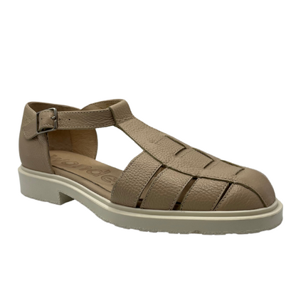 45 degree angled view of beige leather sandal with low heel and buckle strap