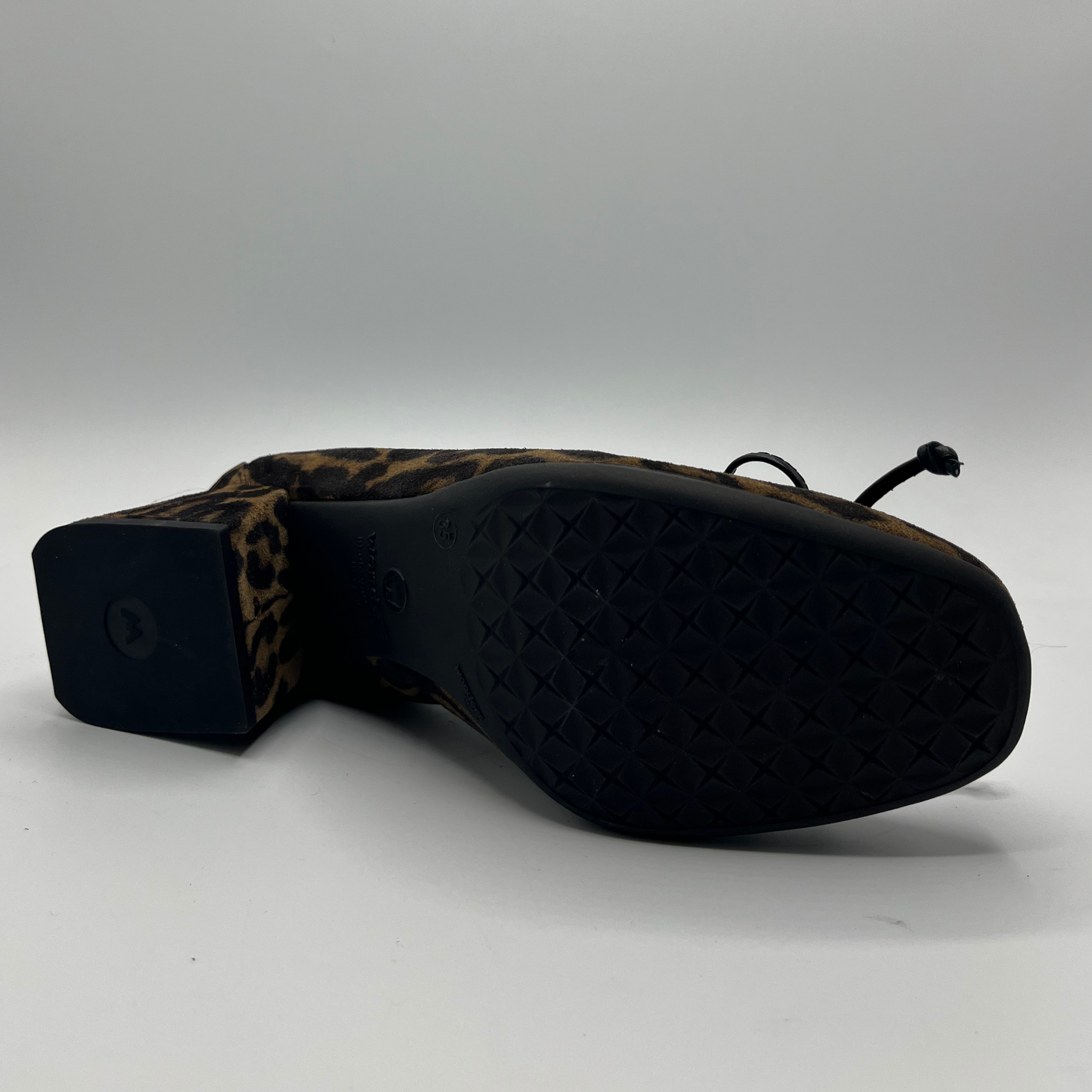 Black shoe with leopard print heel on a white background