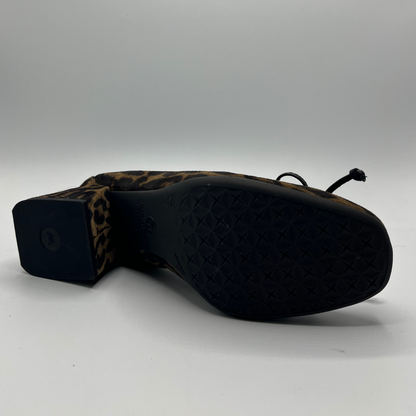 Black shoe with leopard print heel on a white background