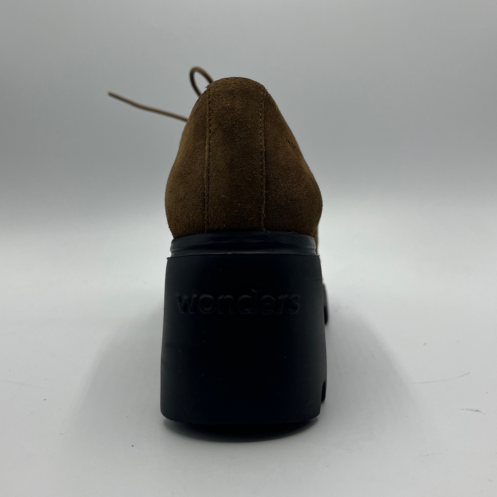 Brown suede shoe with a black sole on a white background