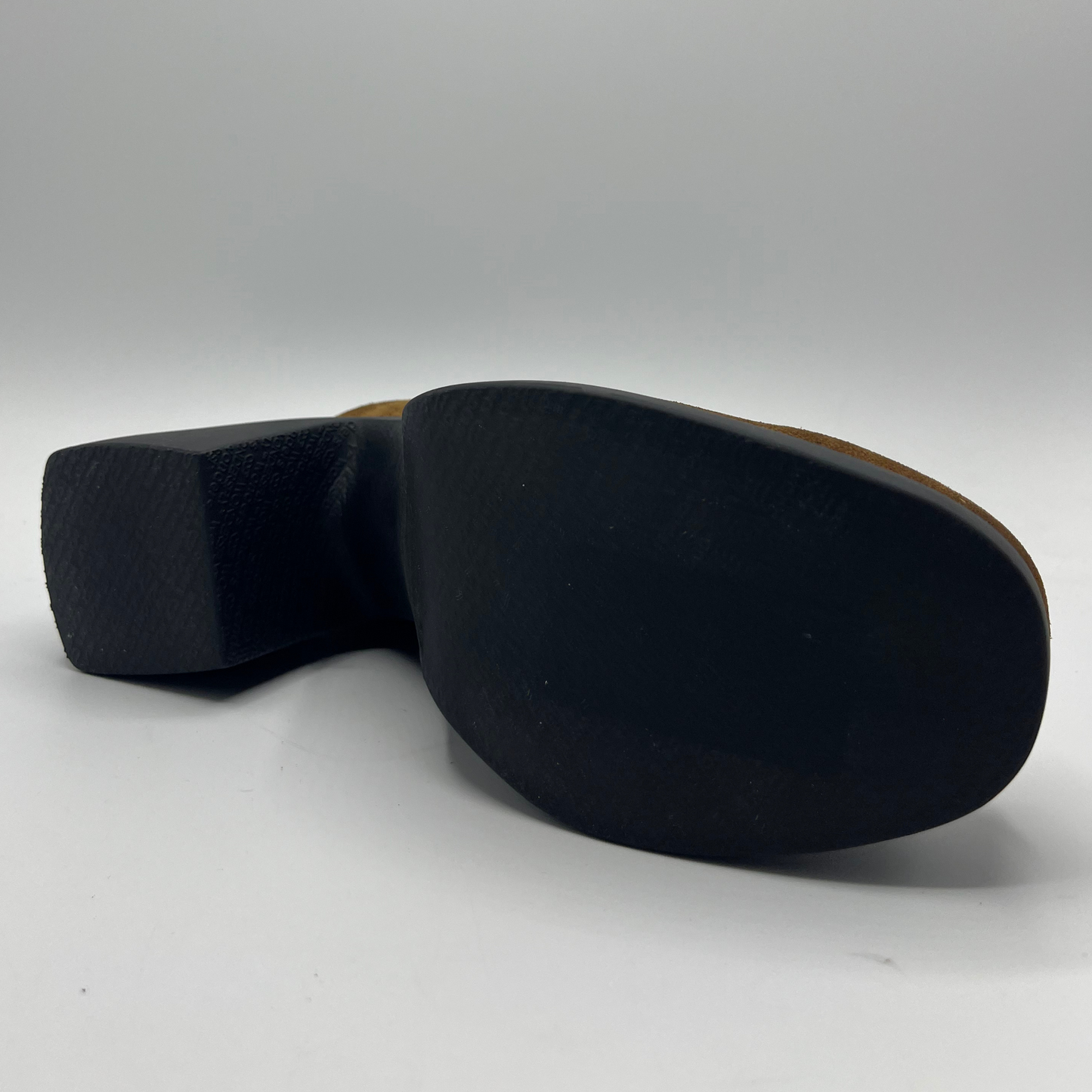Bottom view of a brown suede platform loafer with a black outsole