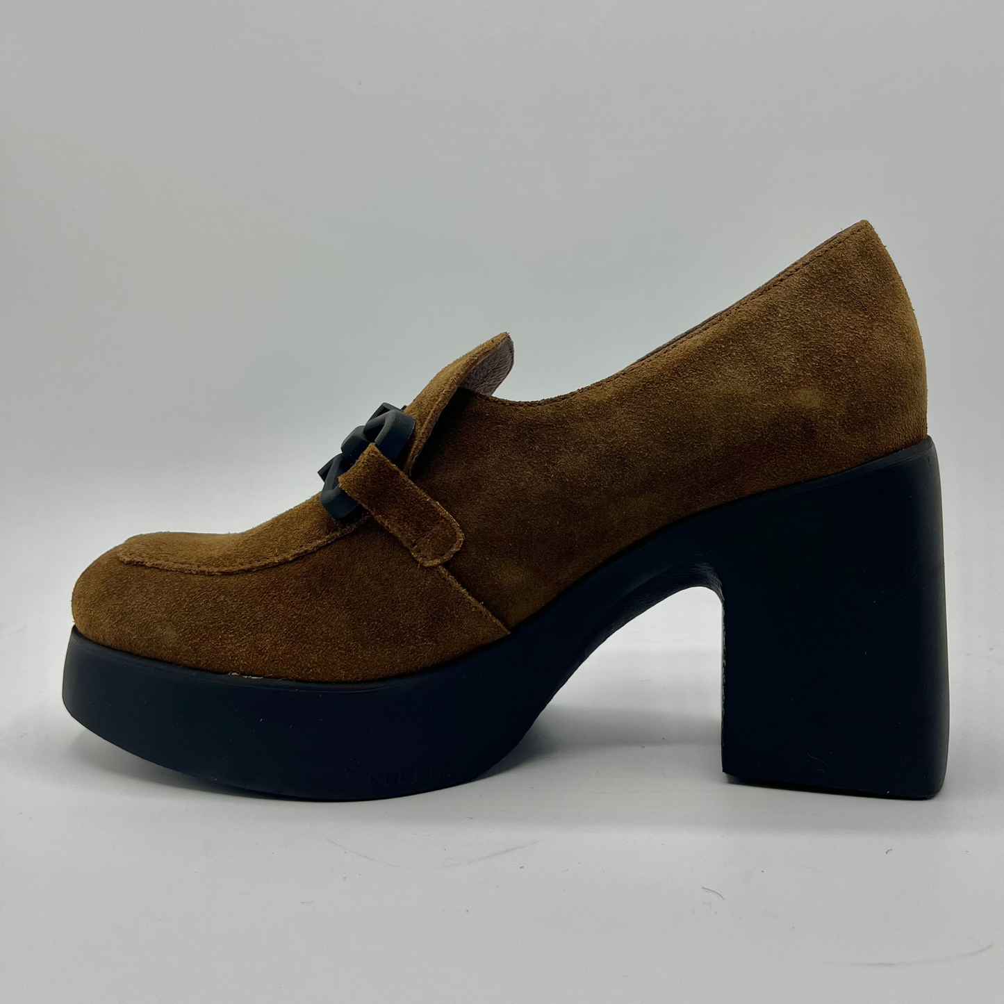 Brown suede shoe with a black platform sole on a white background