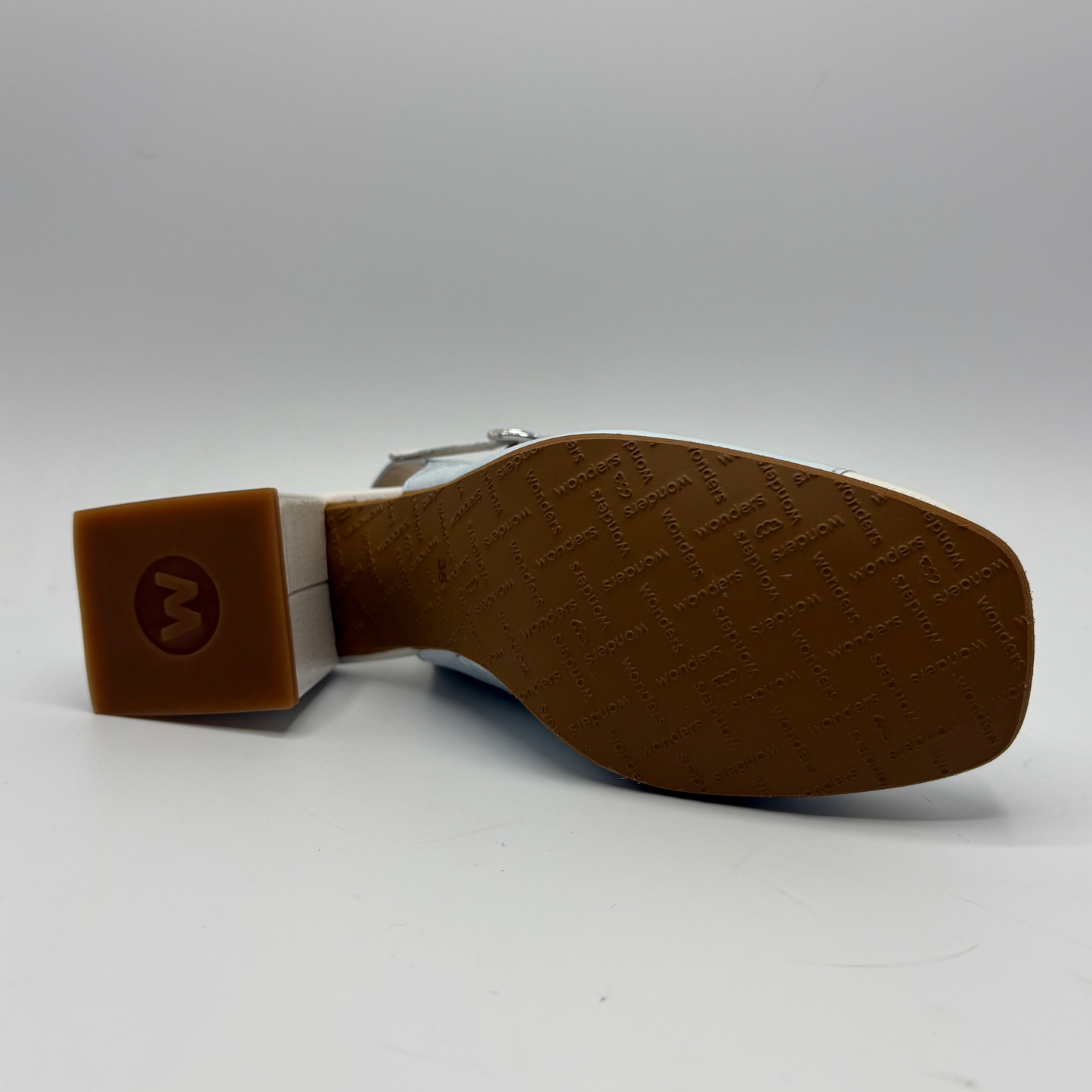 Brown shoe sole with a brand logo on a gray background