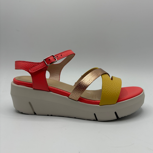 Multicolored sandal with red, yellow, and beige straps on a gray background