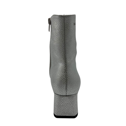 Back facing view of silver textured leather short boot. Short block, side zipper closure and rounded toe