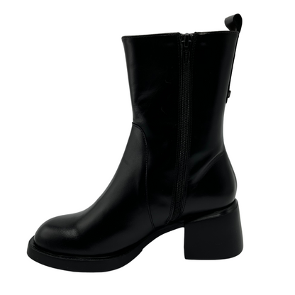 Left facing view of black leather short boot with chunky heel and pull on tab