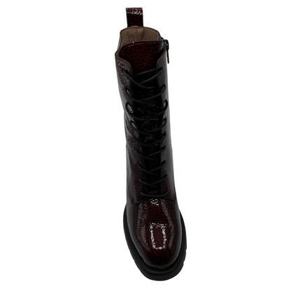 Top view of dark wine coloured patent leather boot. Black lace up closure, chunky black outsole and heel.