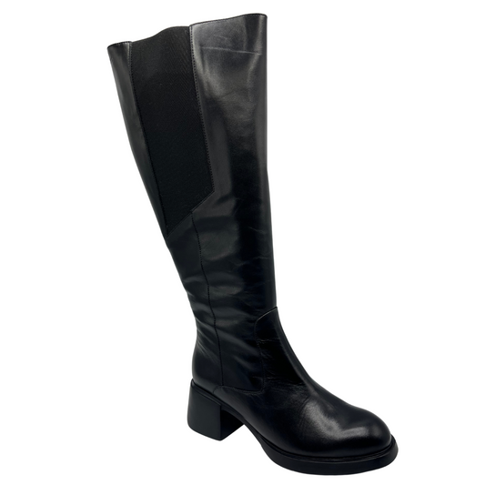 45 degree angled view of black leather boot with elasticated sides and a wide calf fit.