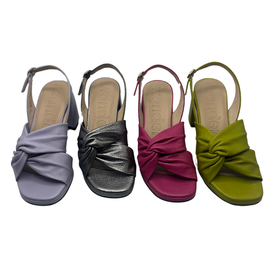 Top view of four leather sandals in a line. Lavender, metallic silver, pink and green apple. 