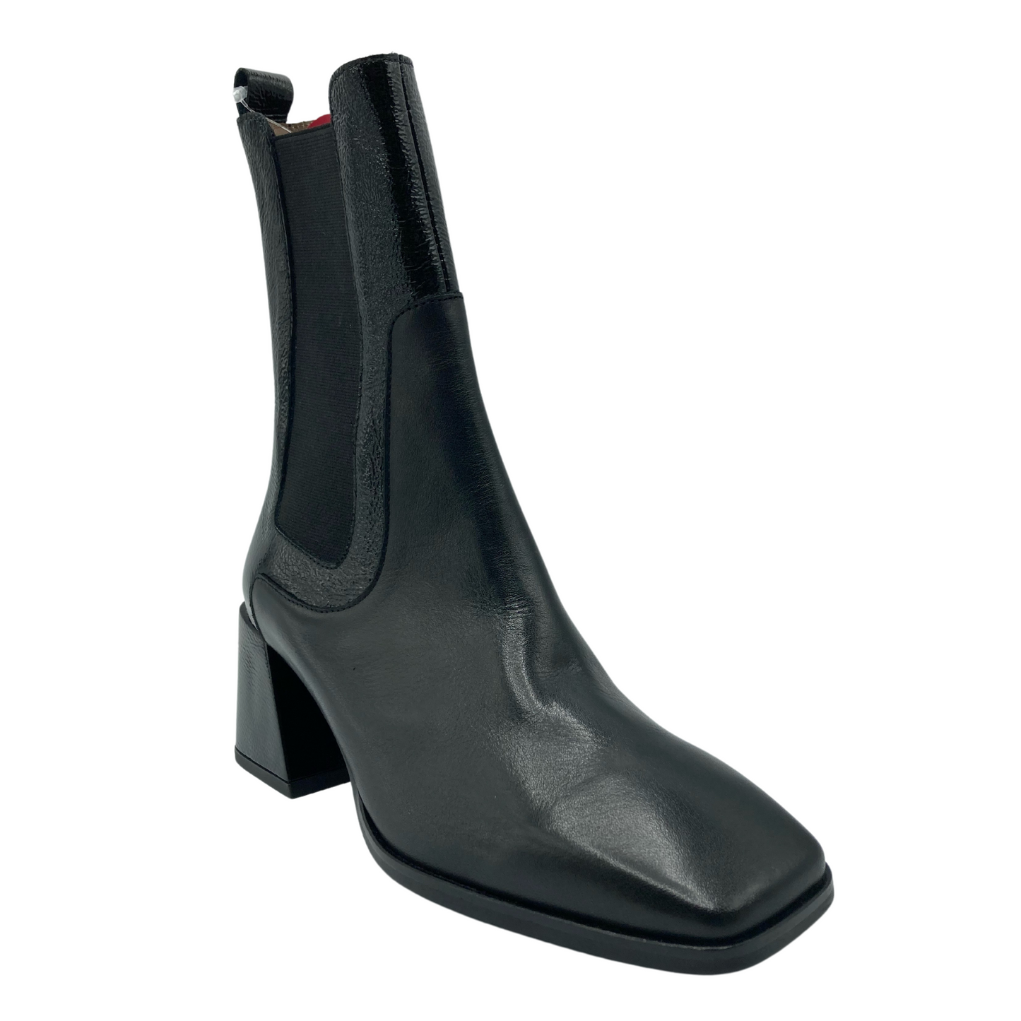 45 degree angled view of black leather short boot with chunky flared heel and elastic side gore