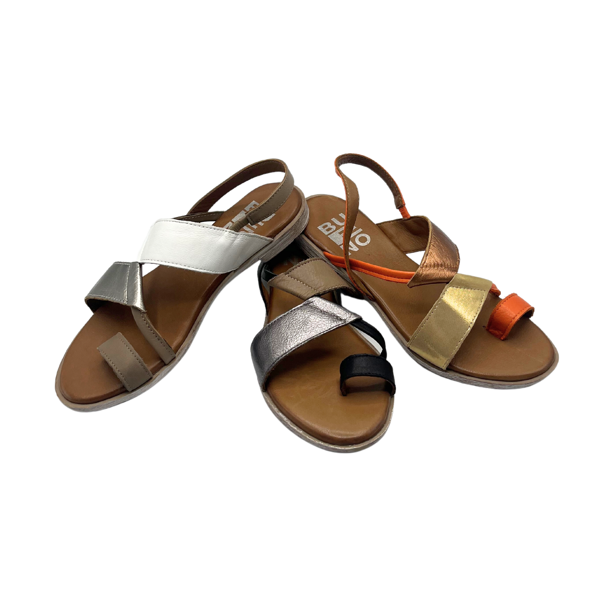 Front view of a slip on, flat sandal in 3 colorways.  White/silver, black/tan, sunset