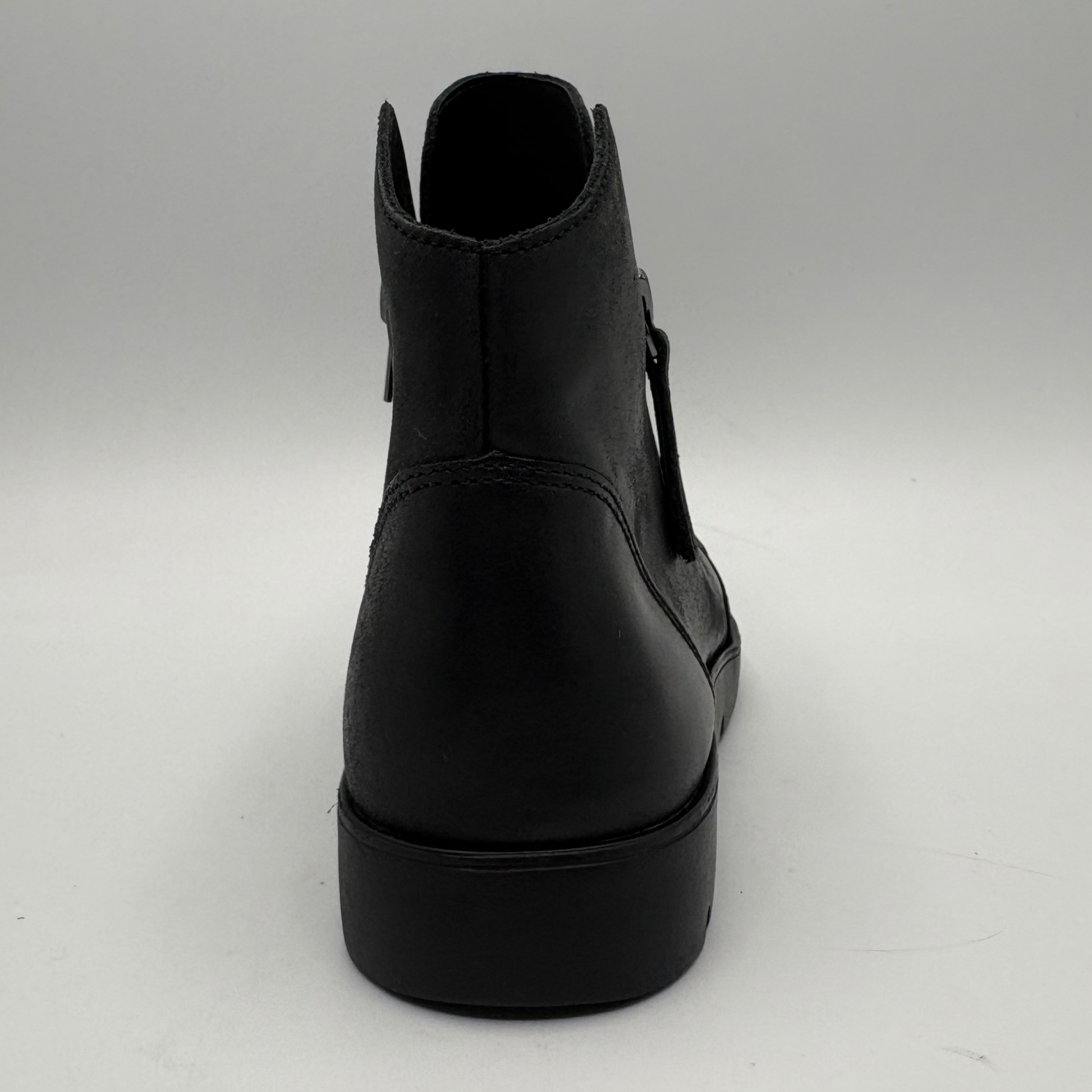 A black leather ankle boot shown from a rear three-quarter view, featuring a thick platform sole and side cutout details, set against a plain light gray background.