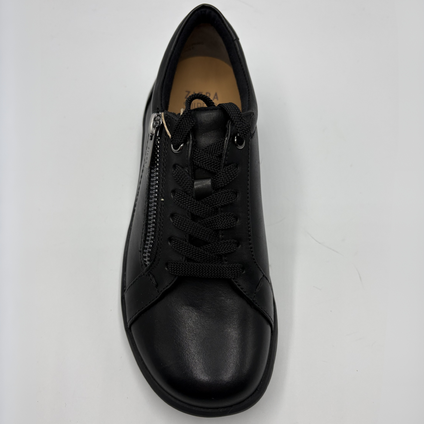 Black sneaker with a zipper on a light gray background