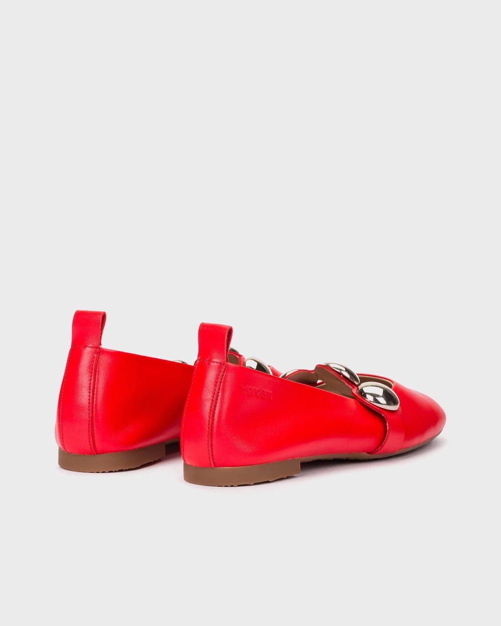 Red loafers with a brown sole on a light gray background