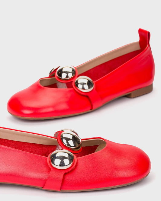 Red flats with gold embellishments on a light gray background