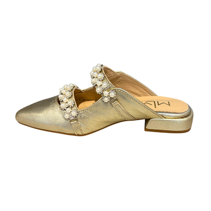 Gold slip-on shoe with pearl and crystal embellishments on a white background