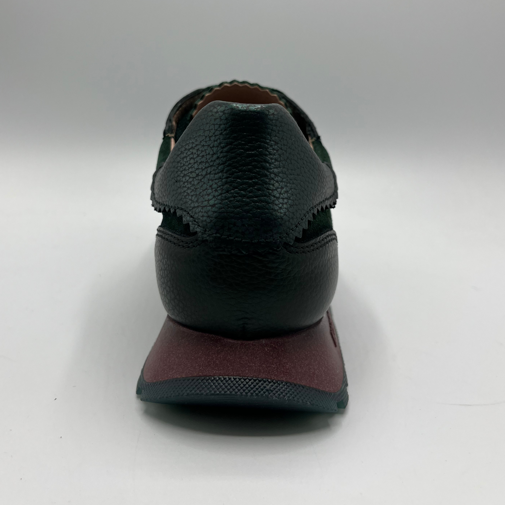 Green shoe with a brown sole on a white background