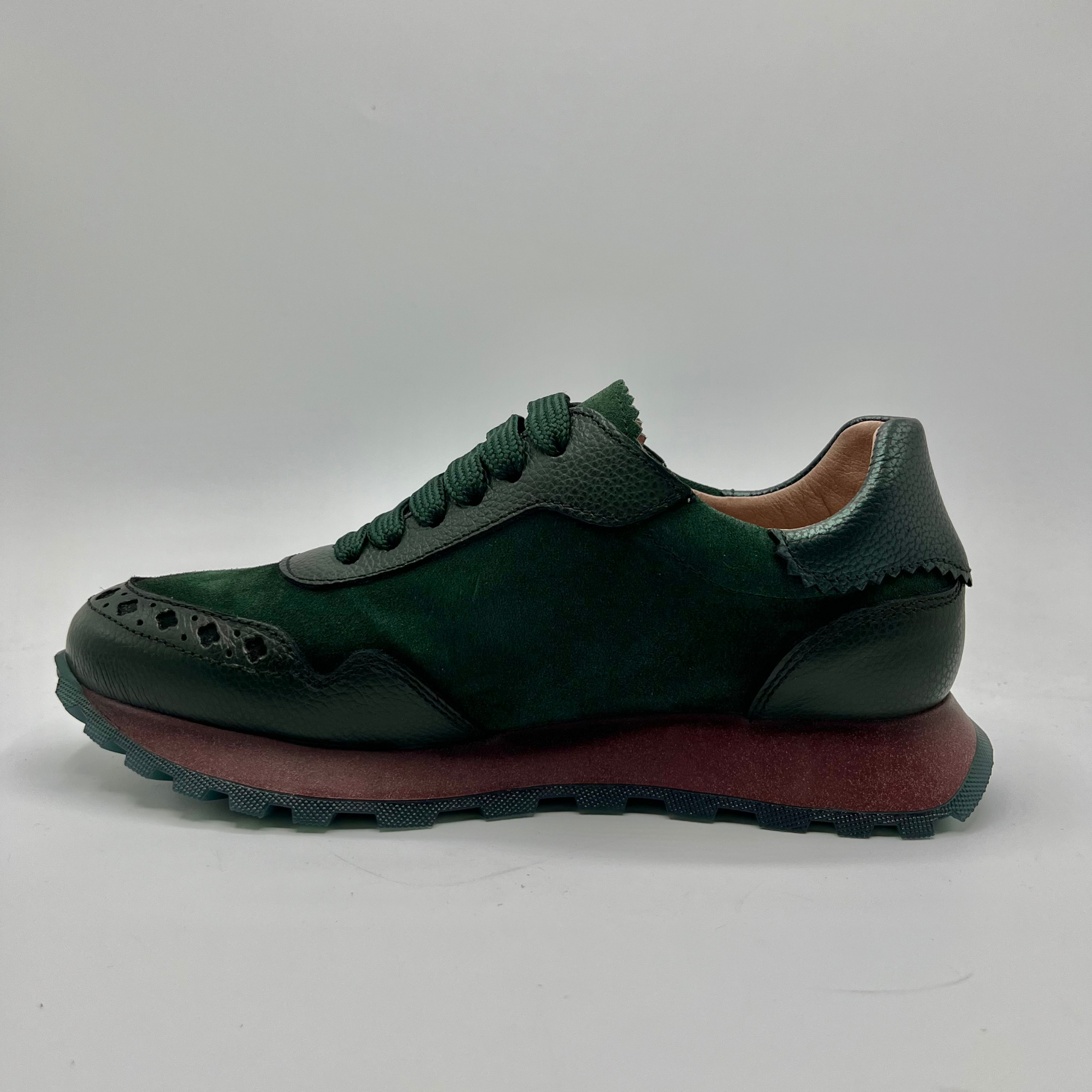 Green sneaker with brown sole on a white background