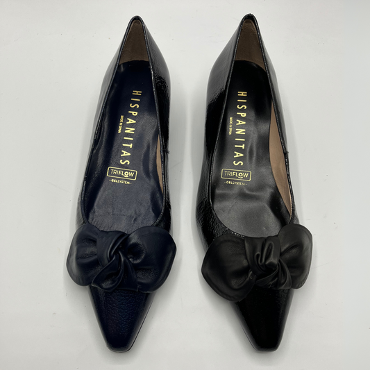 One Navy and one Black high-heeled shoe with bow details on a white background