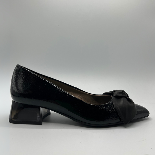 Black patent leather shoe with a bow on a gray background