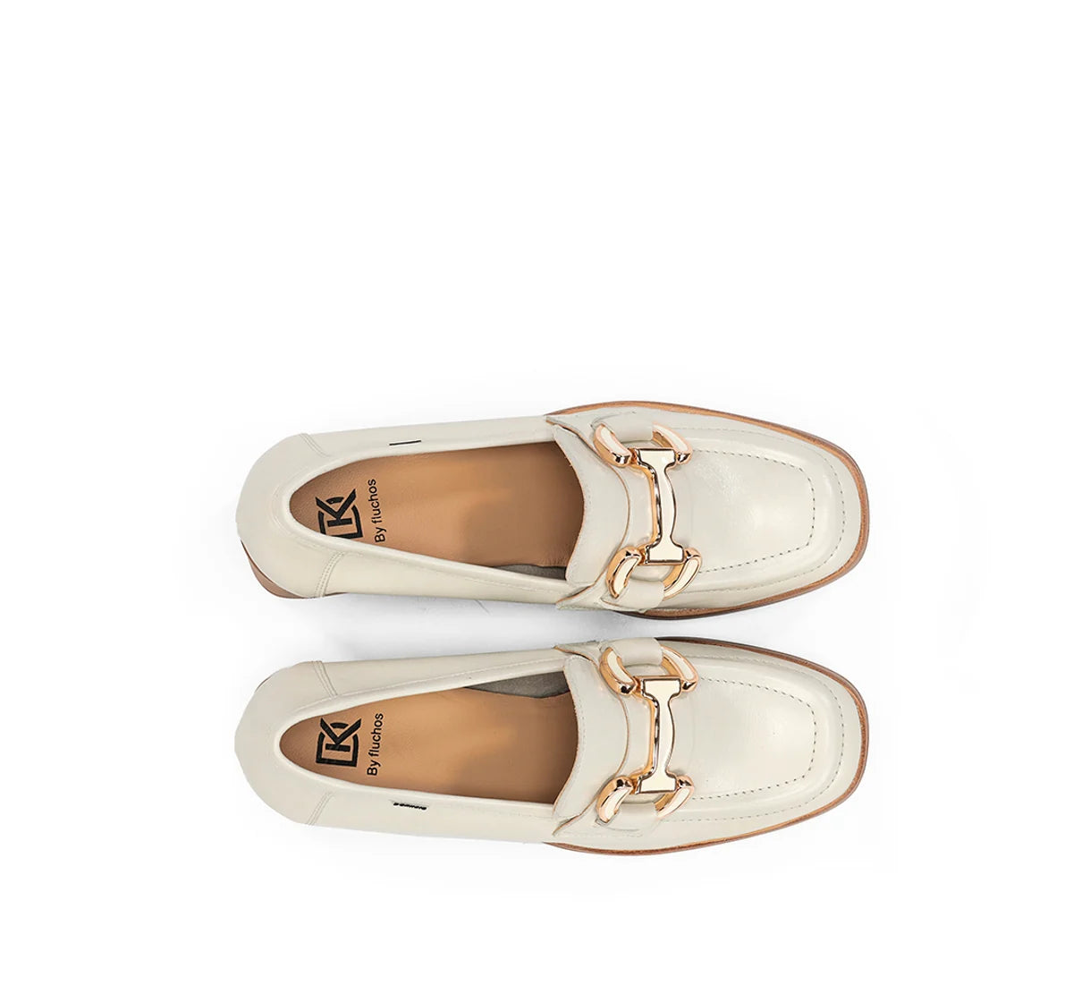 Pair of cream loafers with a gold buckle on a white background