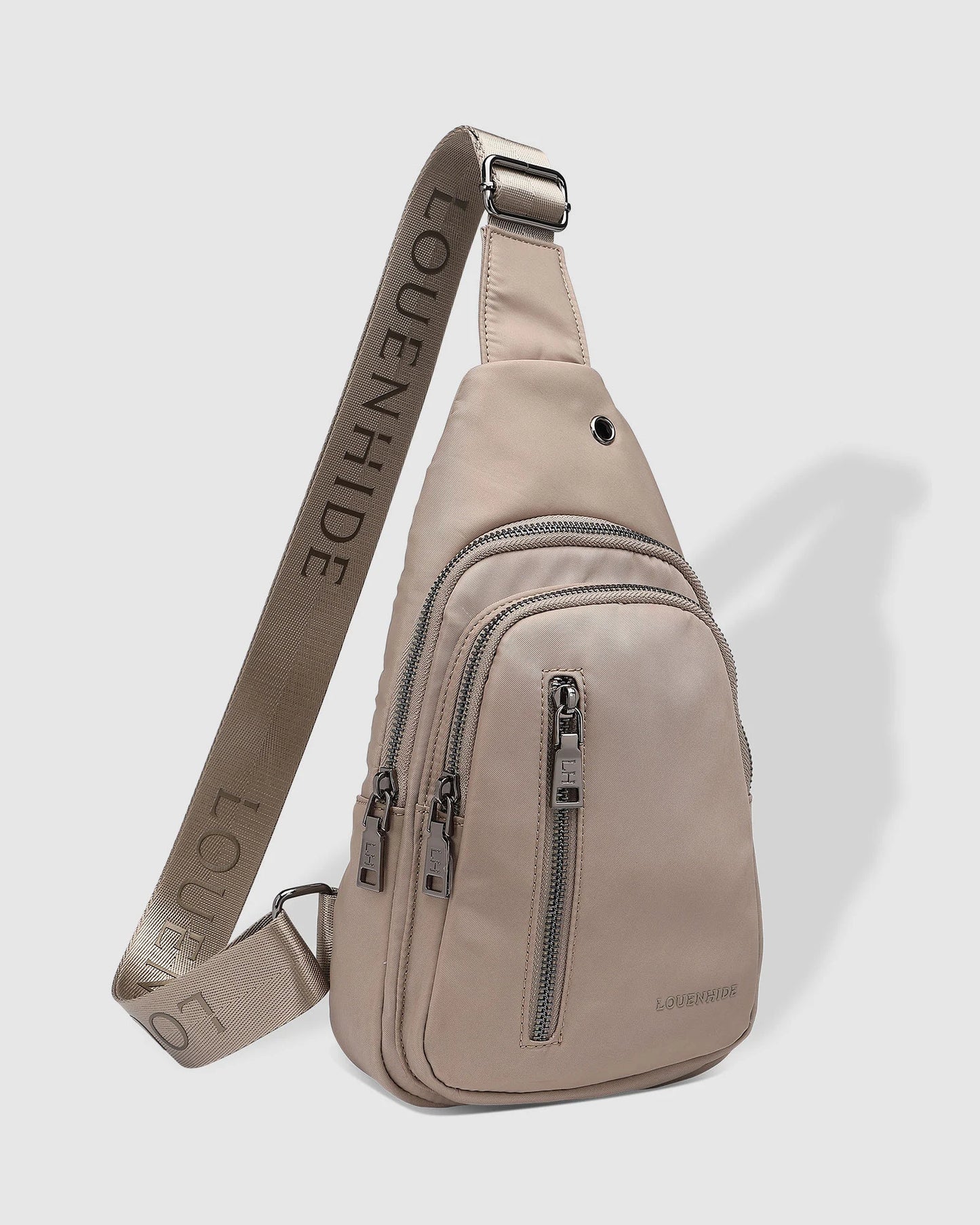 Beige sling bag with visible branding on a light gray background