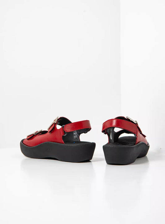 Red sandals with black soles on a white background