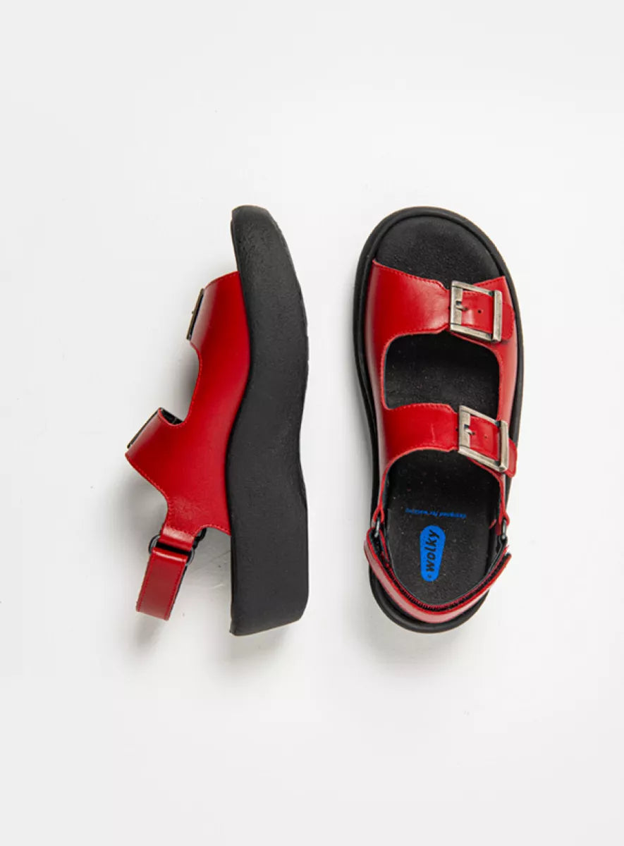 Red sandals with 2 adjustable buckles and black soles on a white  background